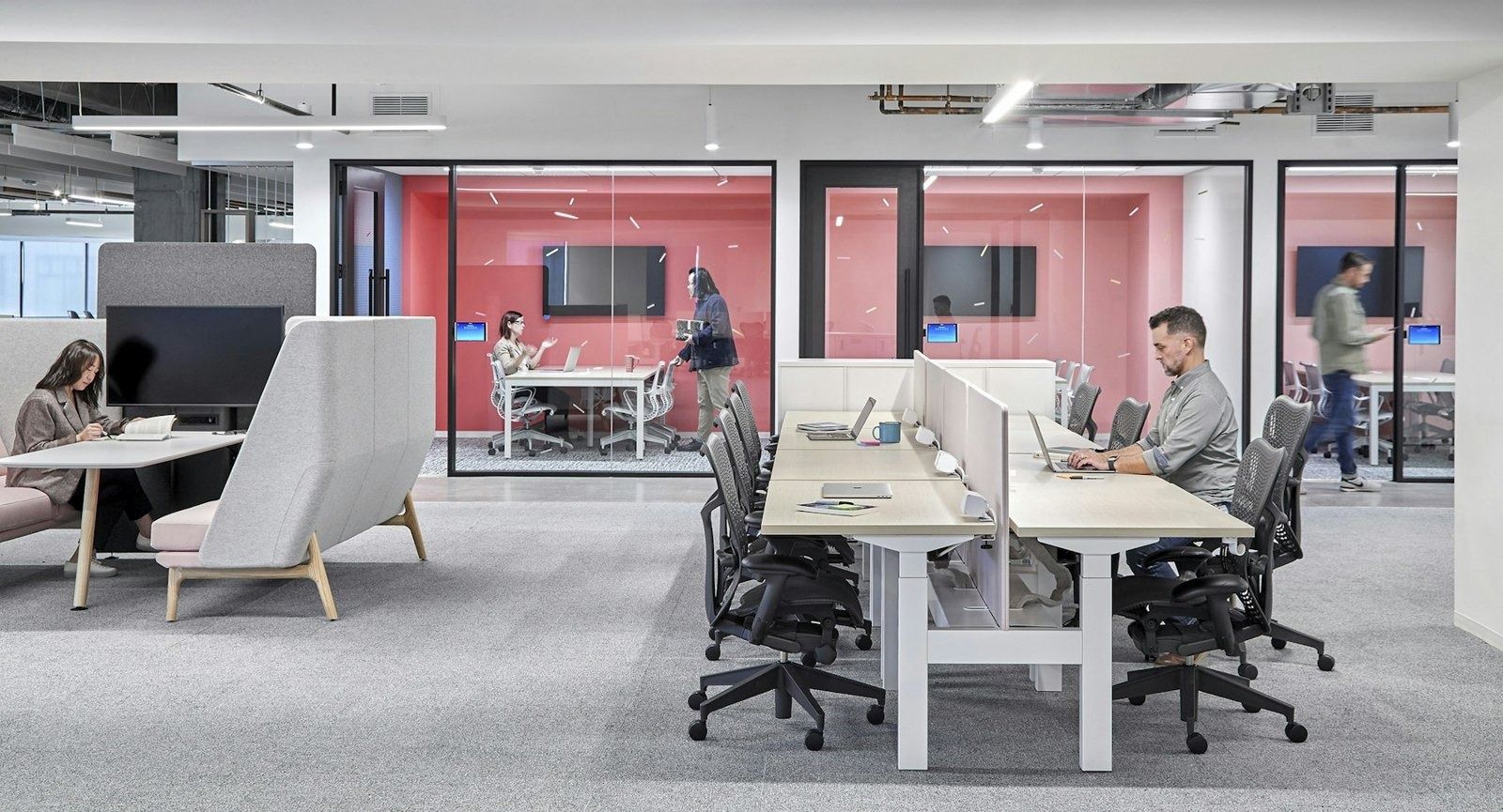 DoorDash: Desk area with red-walled meeting rooms behind