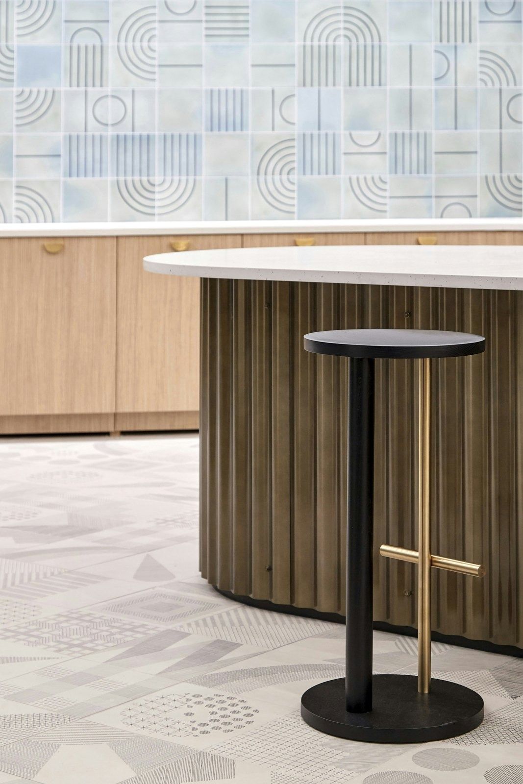 DoorDash: Fluted wooden counter with a black stool on patterned tile