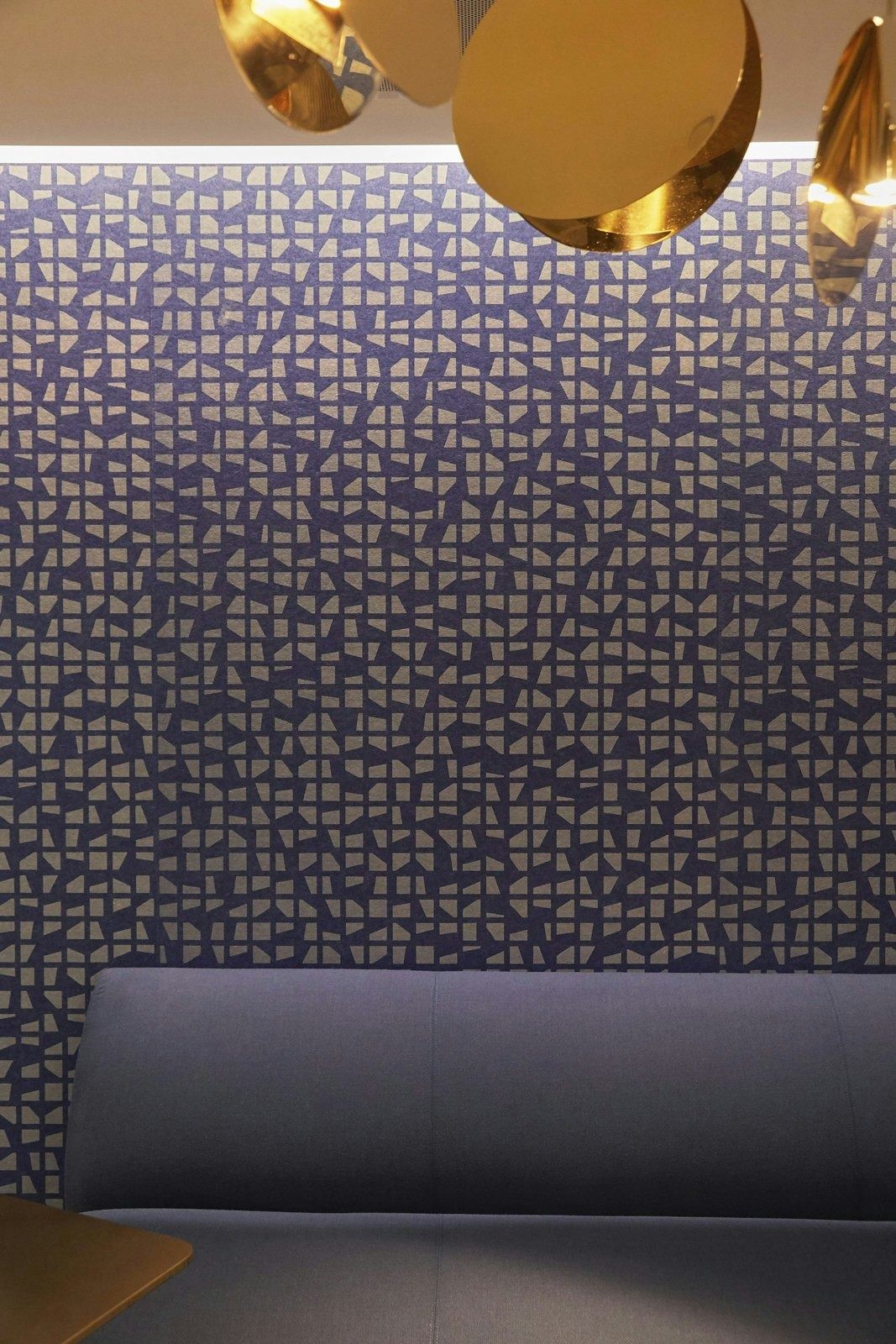 DoorDash: Patterned wall with gold pendant lamps above a banquette