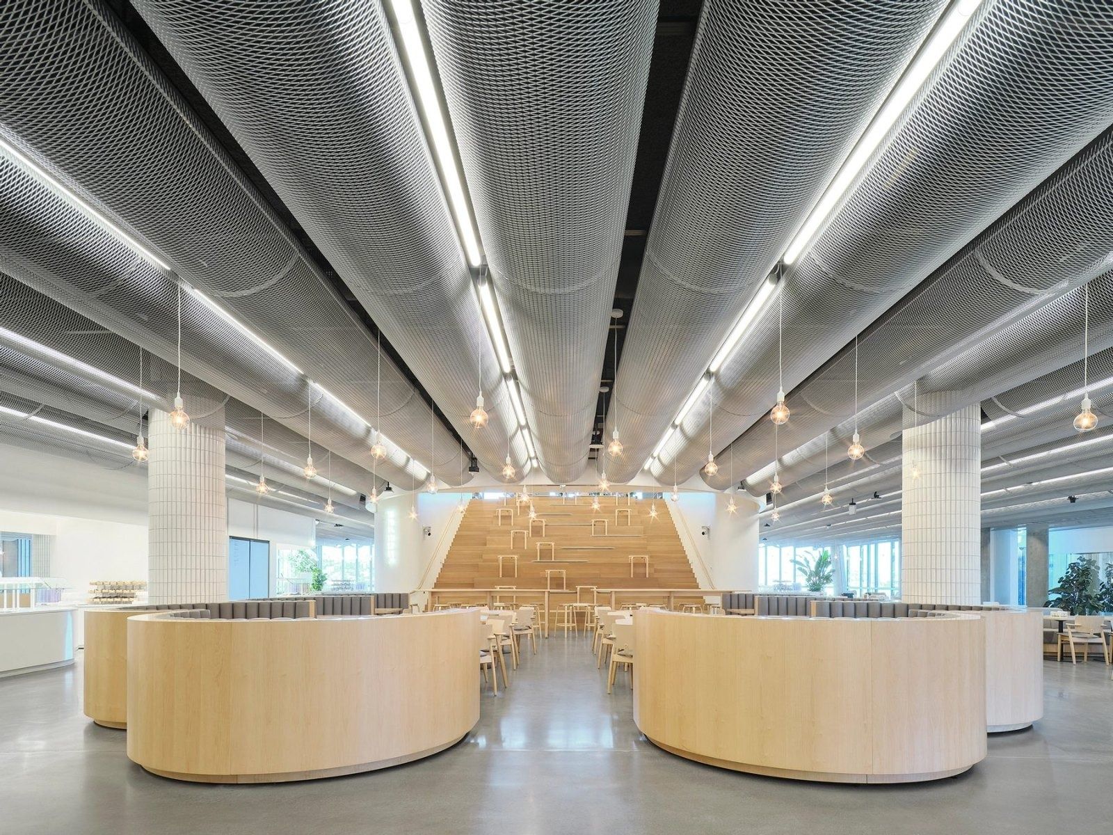 Dropbox: A dining hall with round wooden booths and a stepped seating stair