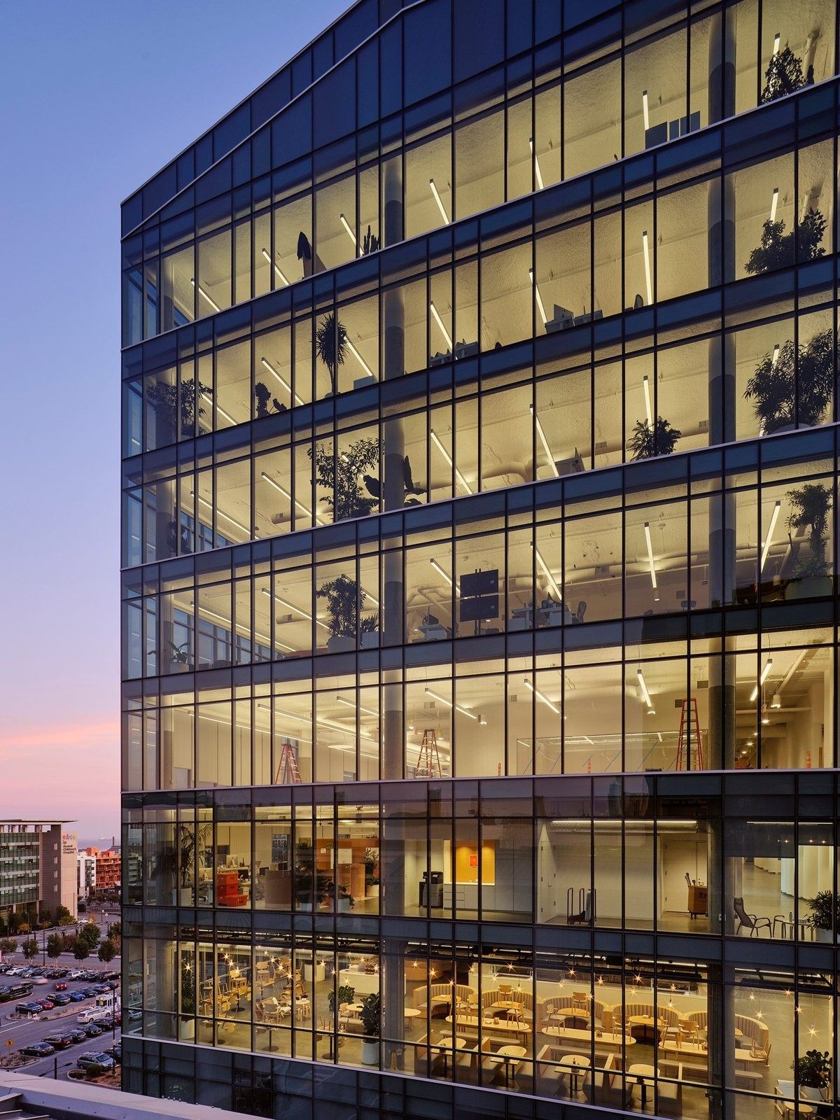 A glass office building lit at dusk