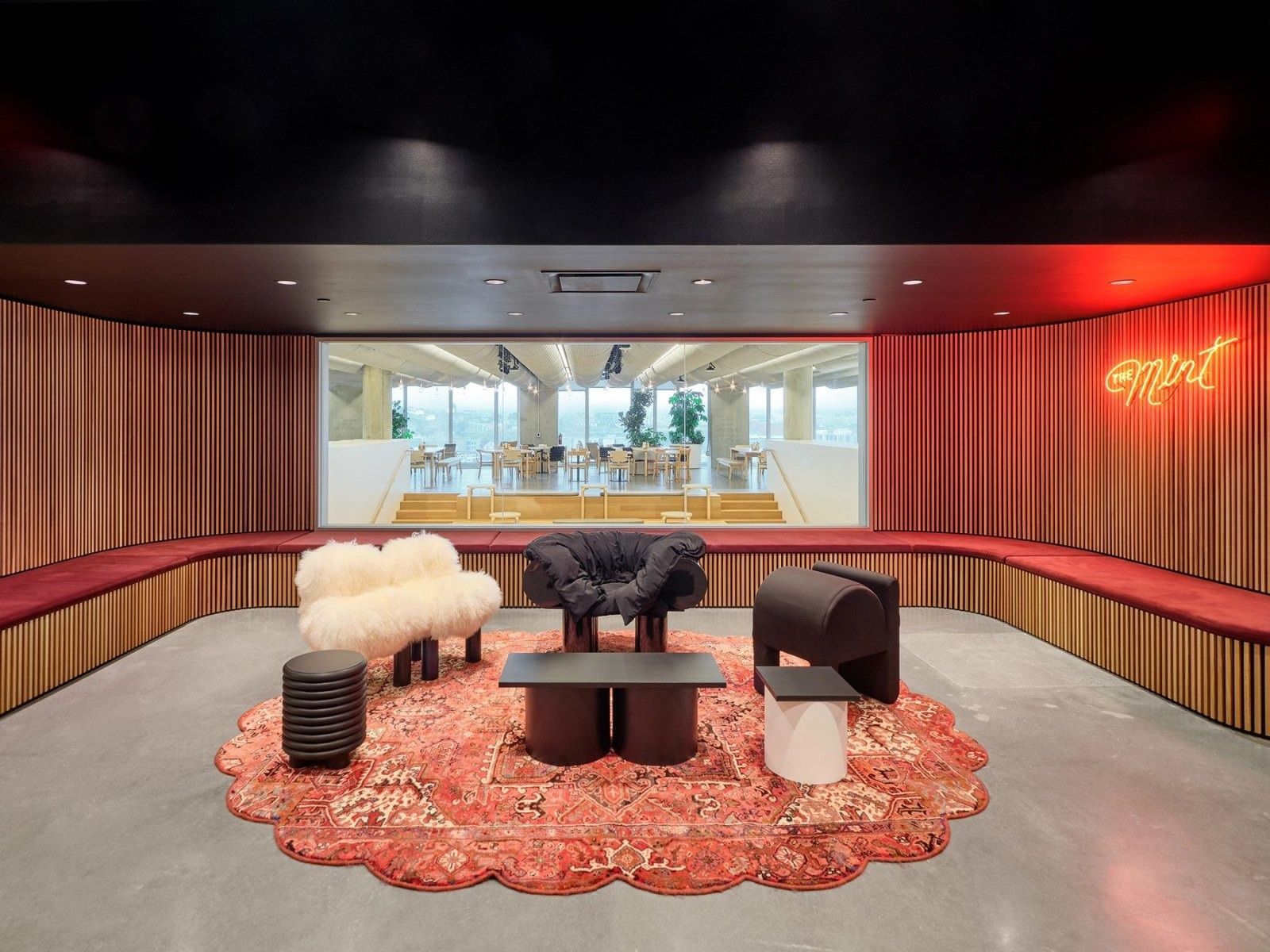 Dropbox: A red-lit karaoke lounge with a round rug and sculptural chairs