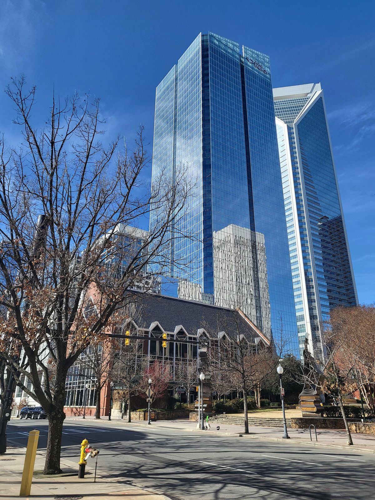 Duke Energy: Glass tower beside a church behind bare trees