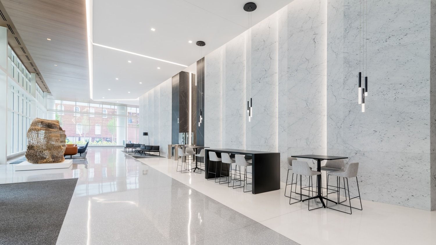 Duke Energy: Lobby with high tables and a boulder sculpture by tall windows