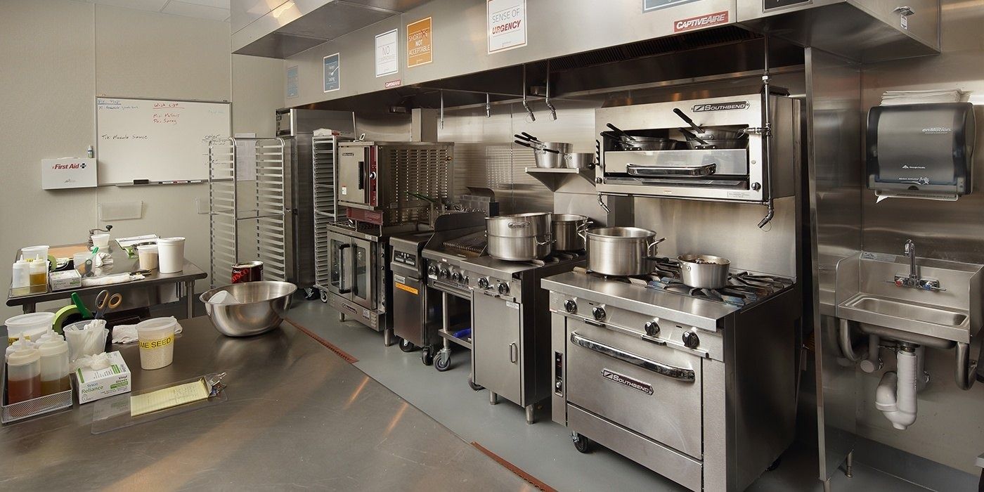 Duolingo: Commercial kitchen with stoves, pots and stainless-steel counters