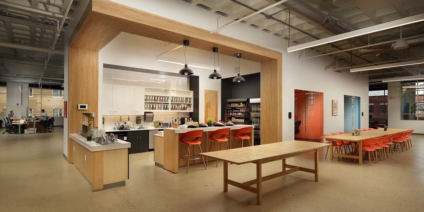 Duolingo: Kitchen counter under a wooden frame with pendant lights and long dining tables