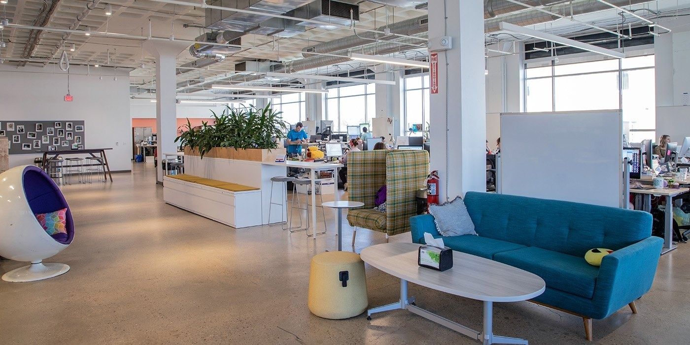 Duolingo: Open office with a blue sofa, an egg chair and planters among desks