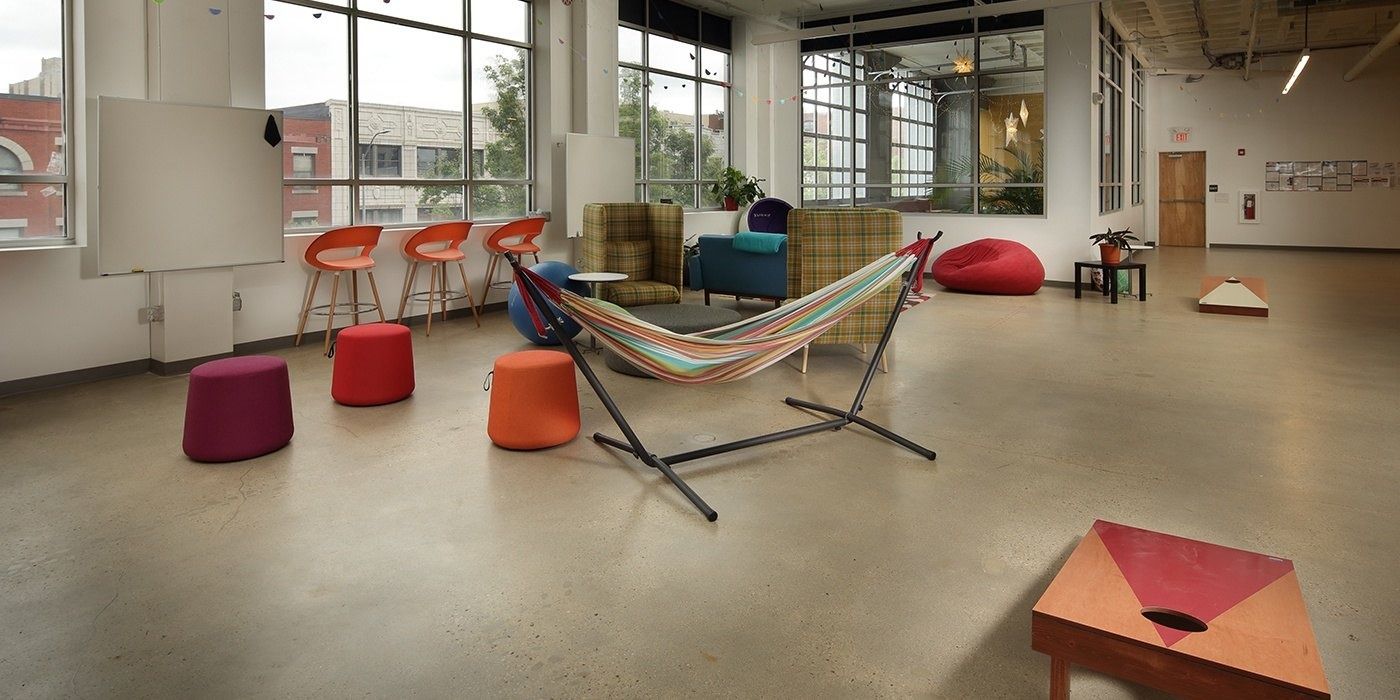 Duolingo: Open space with a hammock, colorful stools and a cornhole board
