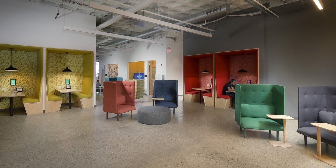 Duolingo: Small enclosed booths with pendant lamps and upholstered armchairs