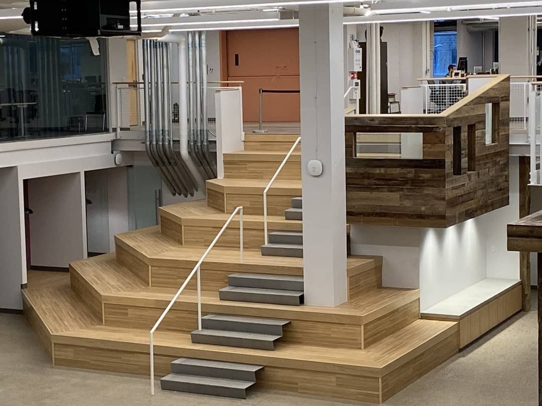 Duolingo: Wide wooden terraced stair with handrails rising to an upper level