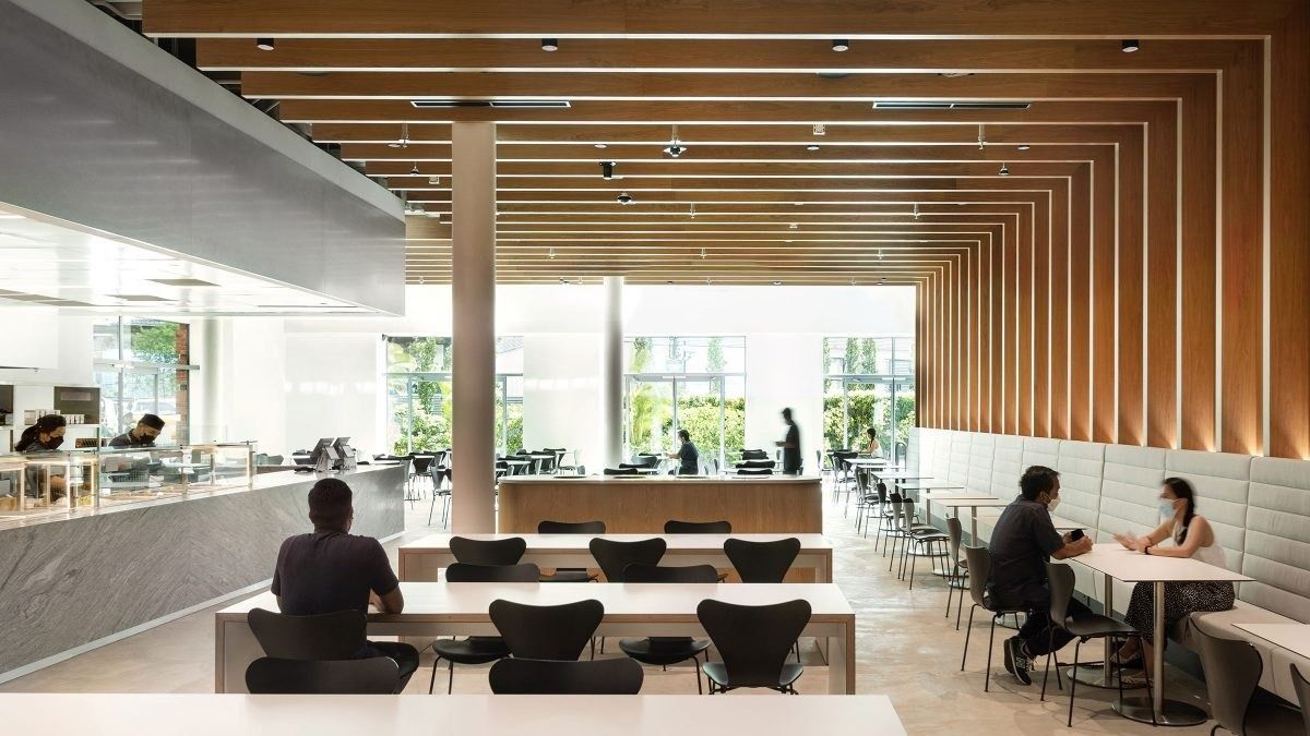 Dyson: Café with long white tables, black chairs and a ceiling of timber slats