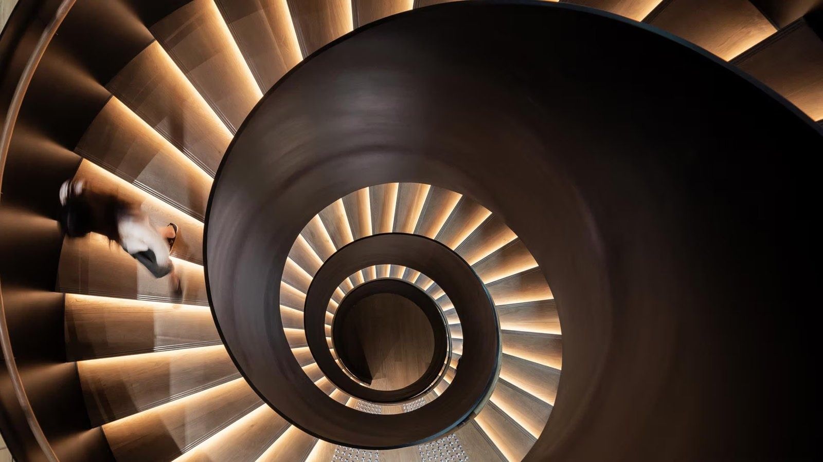 Dyson: Looking down into a black spiral staircase with lit steps