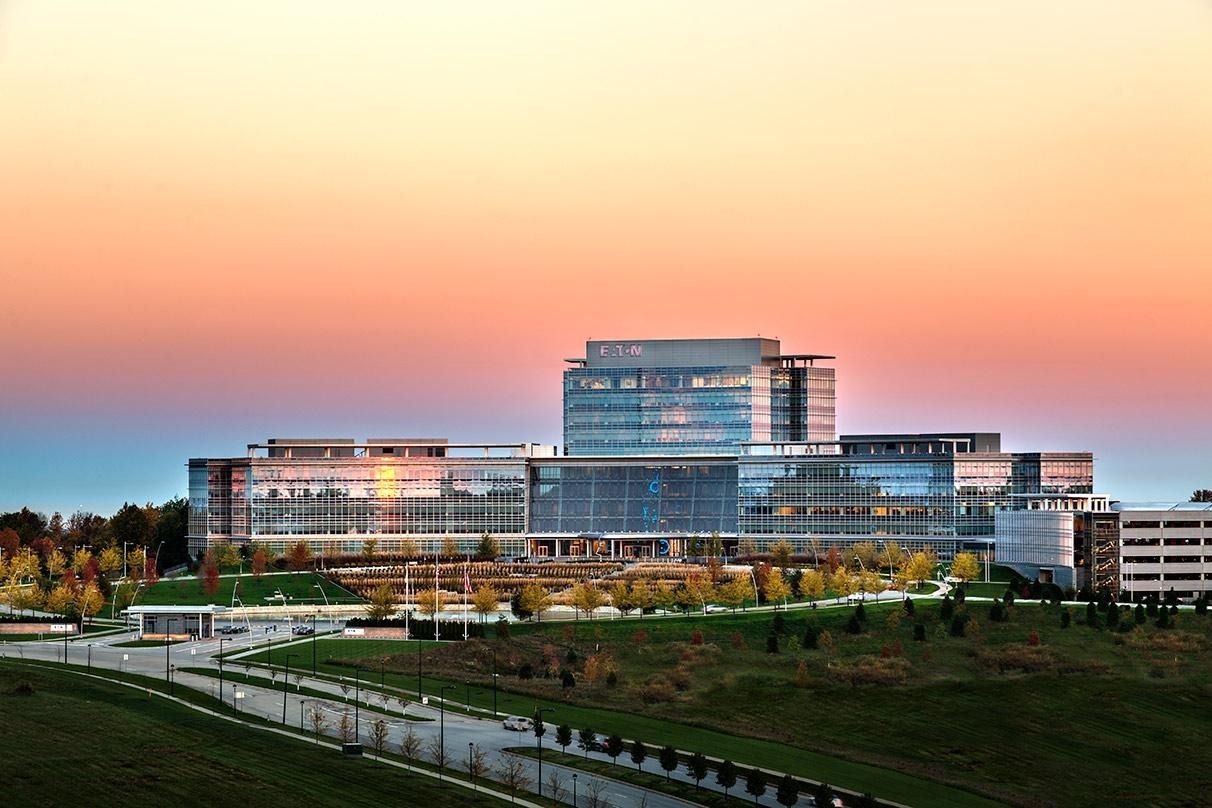 Eaton: A glass office complex on a hill under a pink sunset sky