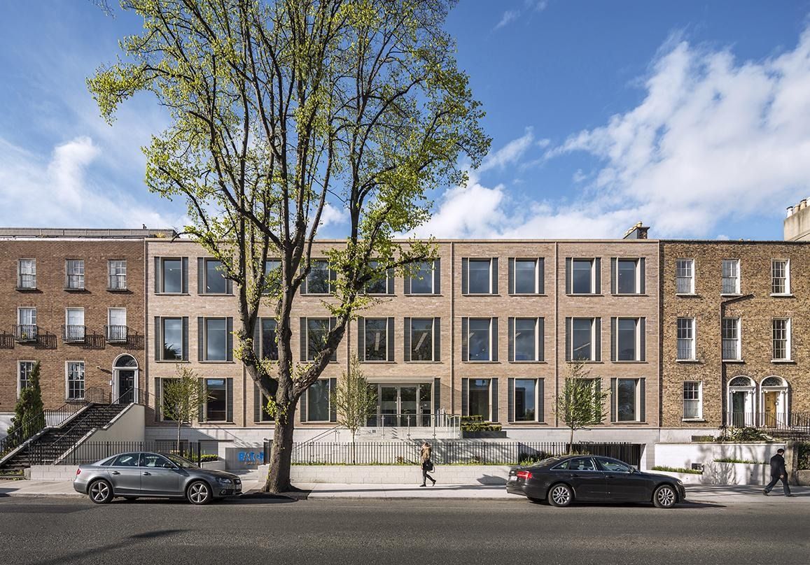 Eaton: A long office front between Georgian brick houses on a tree-lined road