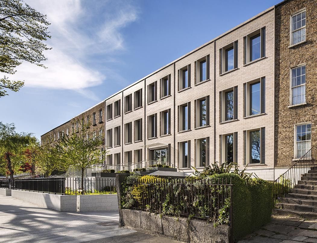 Eaton: A pale brick office facade with tall windows above a stepped garden