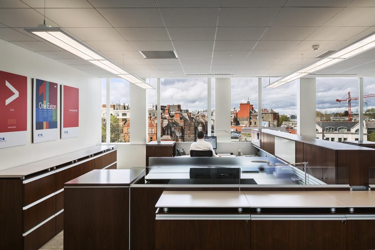 Eaton: An open office kitchen with dark wood counters and windows over Dublin rooftops
