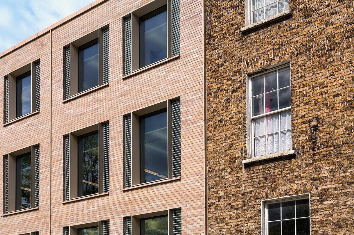 Eaton: Close-up of new brick and window frames beside an old Georgian wall