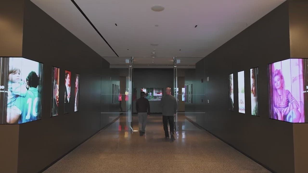 eBay: Dark gallery corridor lined with large portrait screens