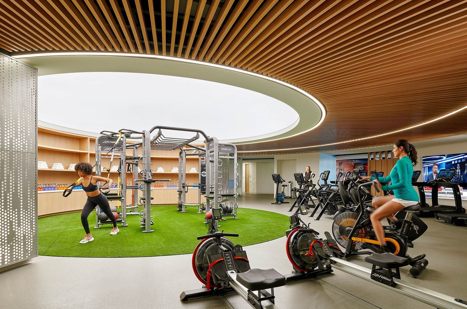 Edwards Lifesciences: A fitness area with a turf floor, a rig, bikes and rowers under a round timber ceiling