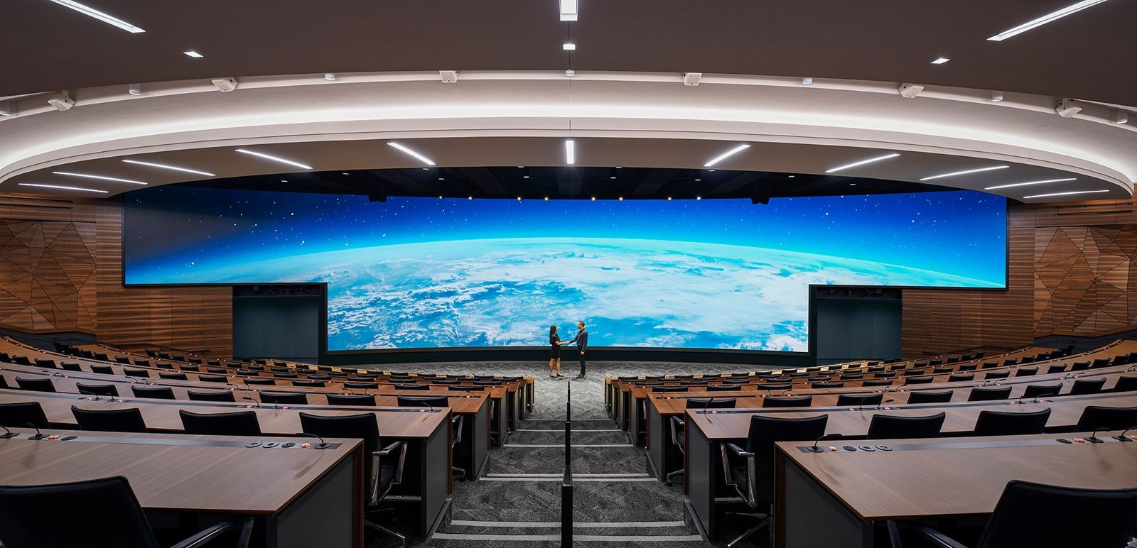 Edwards Lifesciences: A tiered auditorium with long desks facing a huge curved LED screen showing the Earth