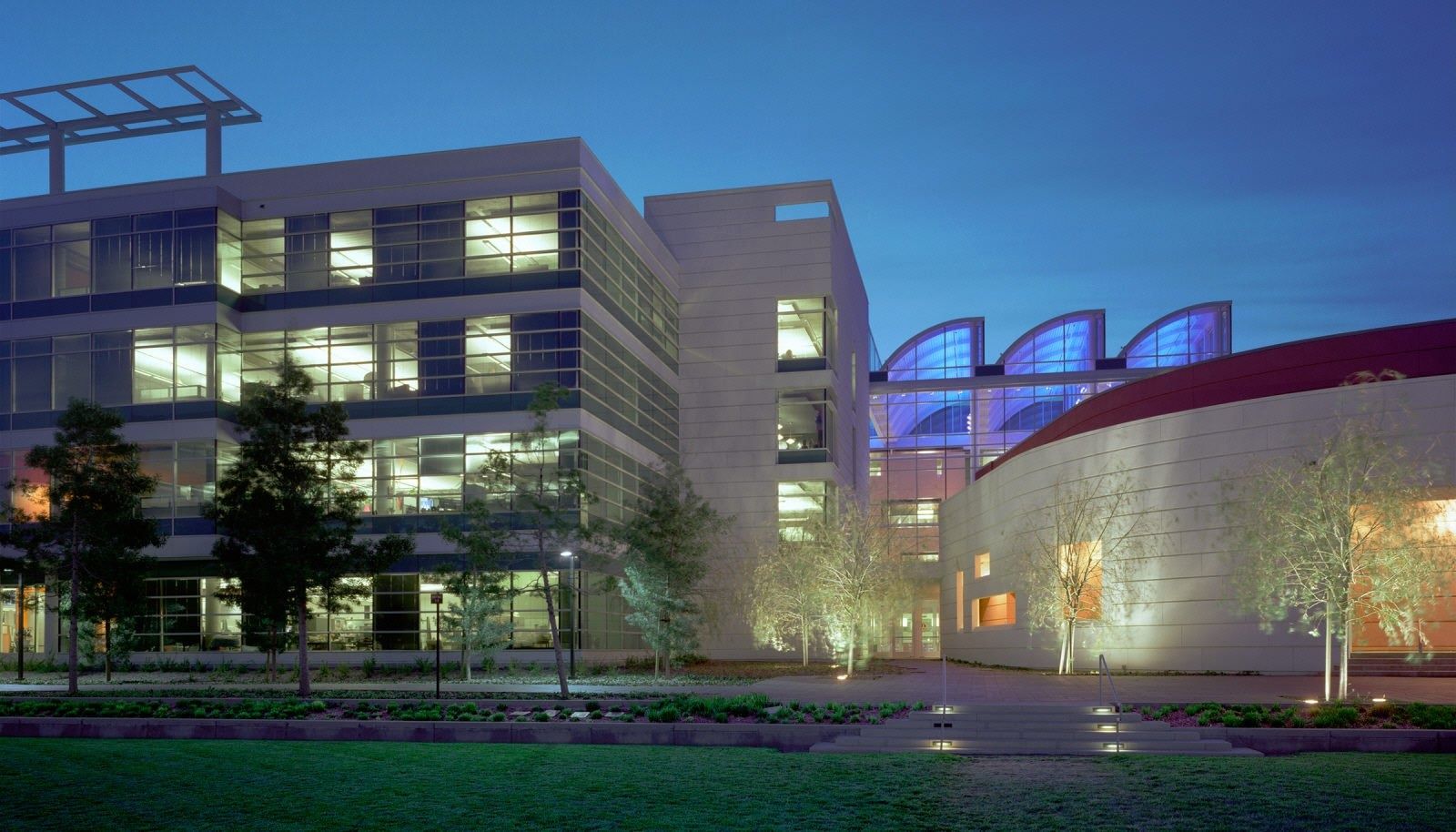 Electronic Arts: Campus buildings lit at dusk with a curved auditorium roof