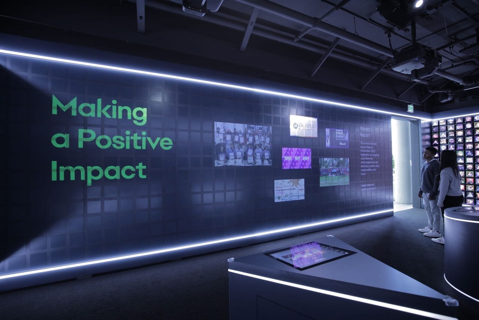 Electronic Arts: Exhibit wall titled Making a Positive Impact with touch tables