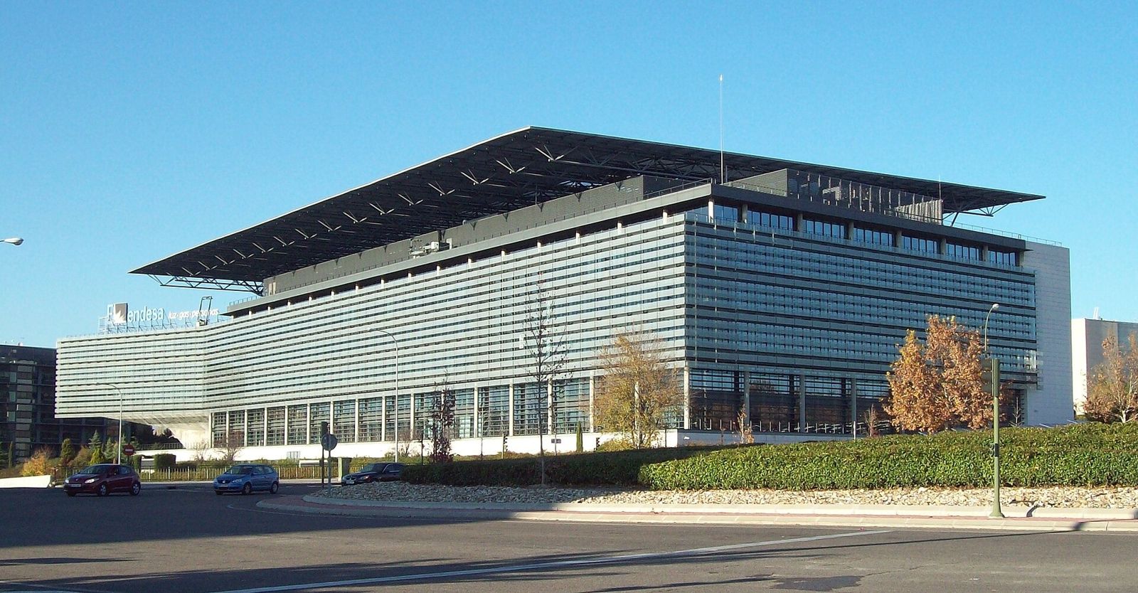Endesa: A long office block with a deep flat roof canopy across a busy road