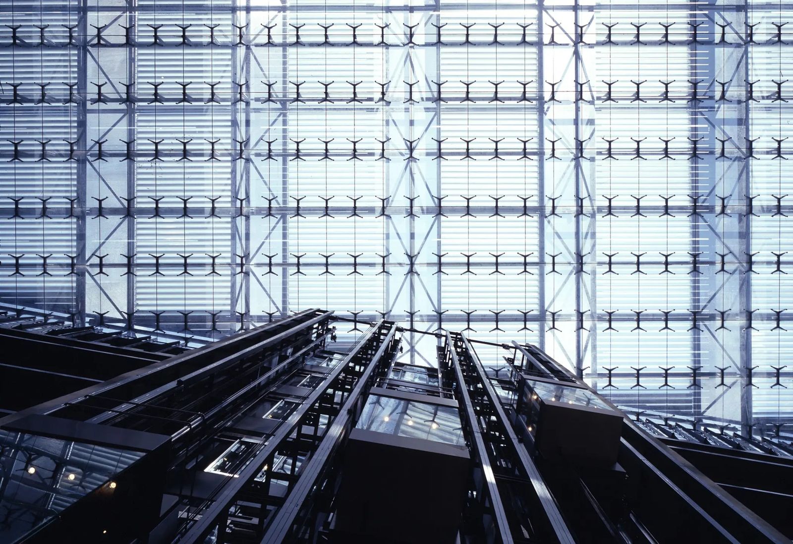 Endesa: Escalators rising toward a vast wall of glass and steel in an atrium