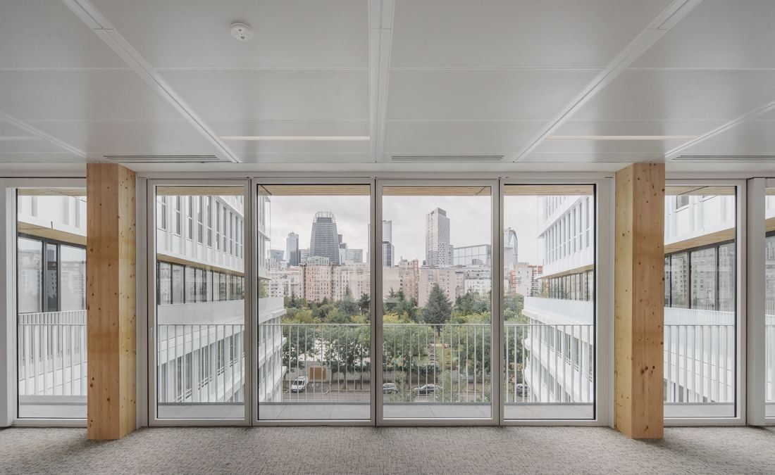 ENGIE: Bright office space with timber columns and floor-to-ceiling windows looking out to towers in the distance