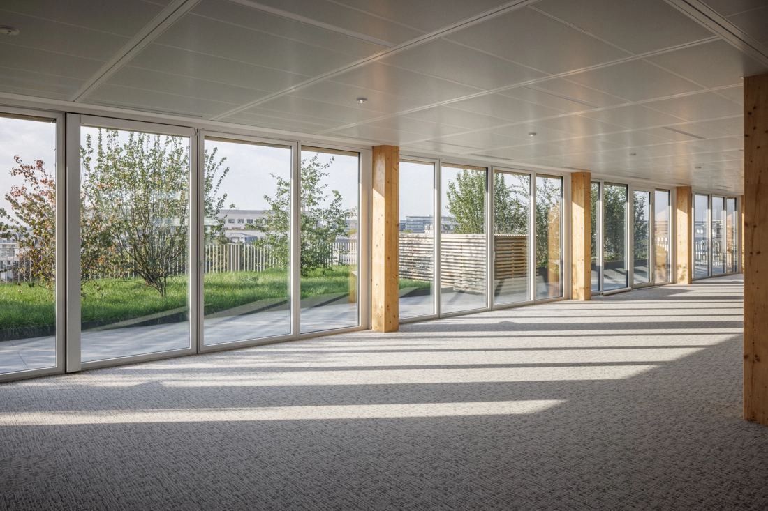 ENGIE: Empty open office floor with full-height windows and timber columns looking onto a planted terrace