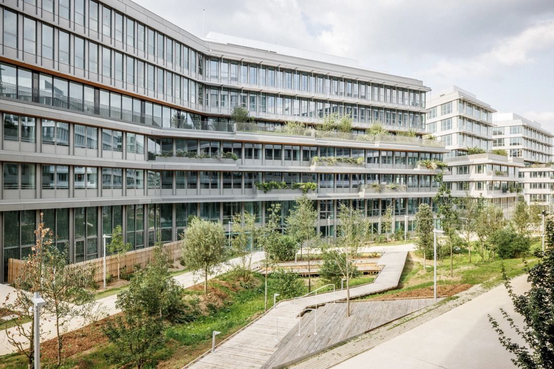 ENGIE: Glass and timber-banded office building beside landscaped paths and young trees
