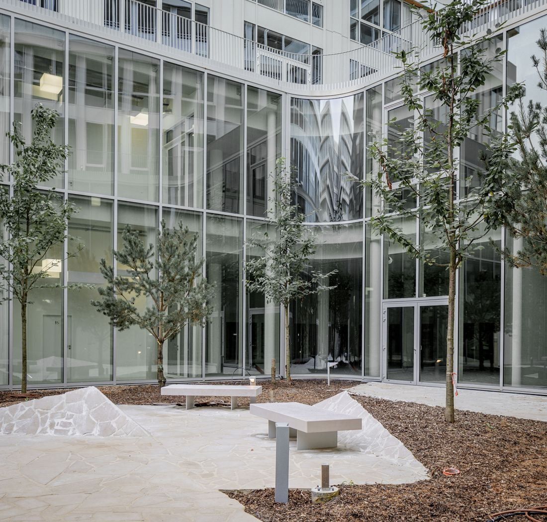 ENGIE: Glazed courtyard with young trees, stone benches and sculpted stone blocks