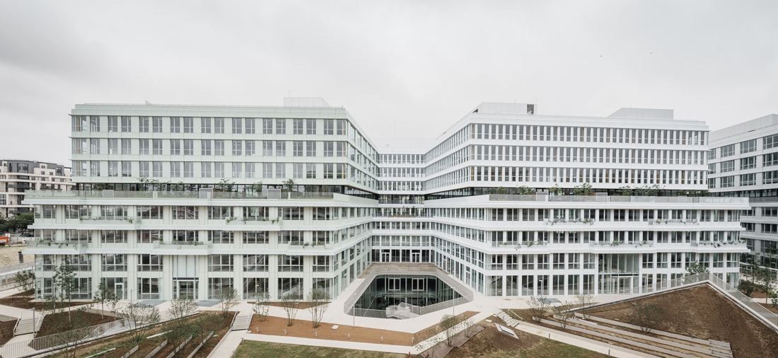 ENGIE: Long white low-rise office buildings framing a central courtyard with lawns