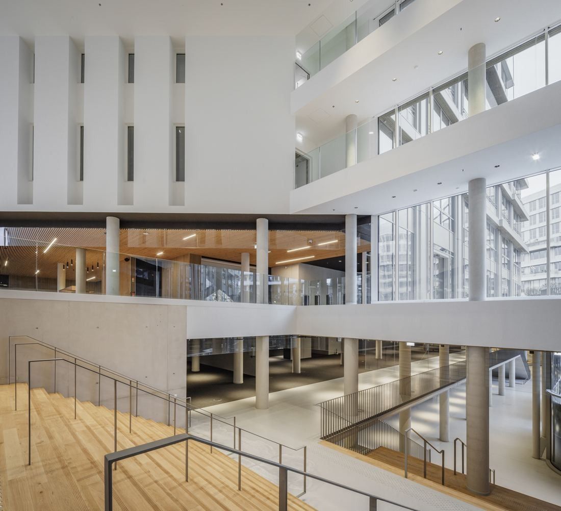 ENGIE: White multi-level atrium with wooden floors, railings and views across several floors