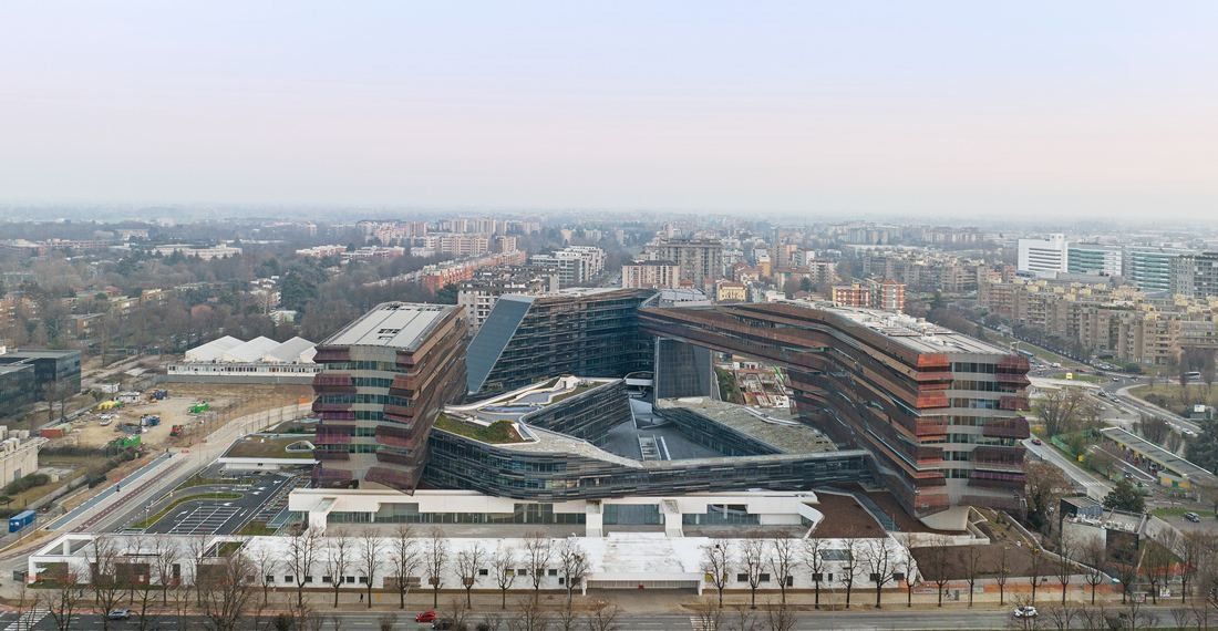 Eni: Aerial view of a cluster of layered office blocks around a central courtyard in a city