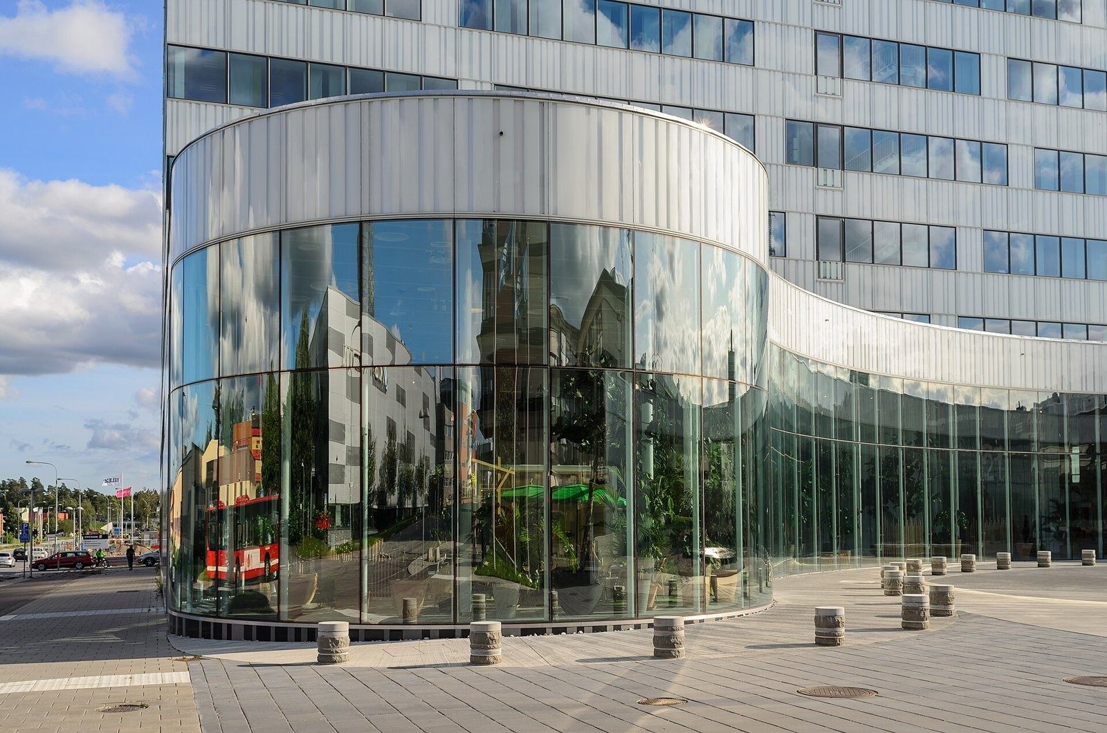 Ericsson: Curved glass ground-floor volume reflecting the street