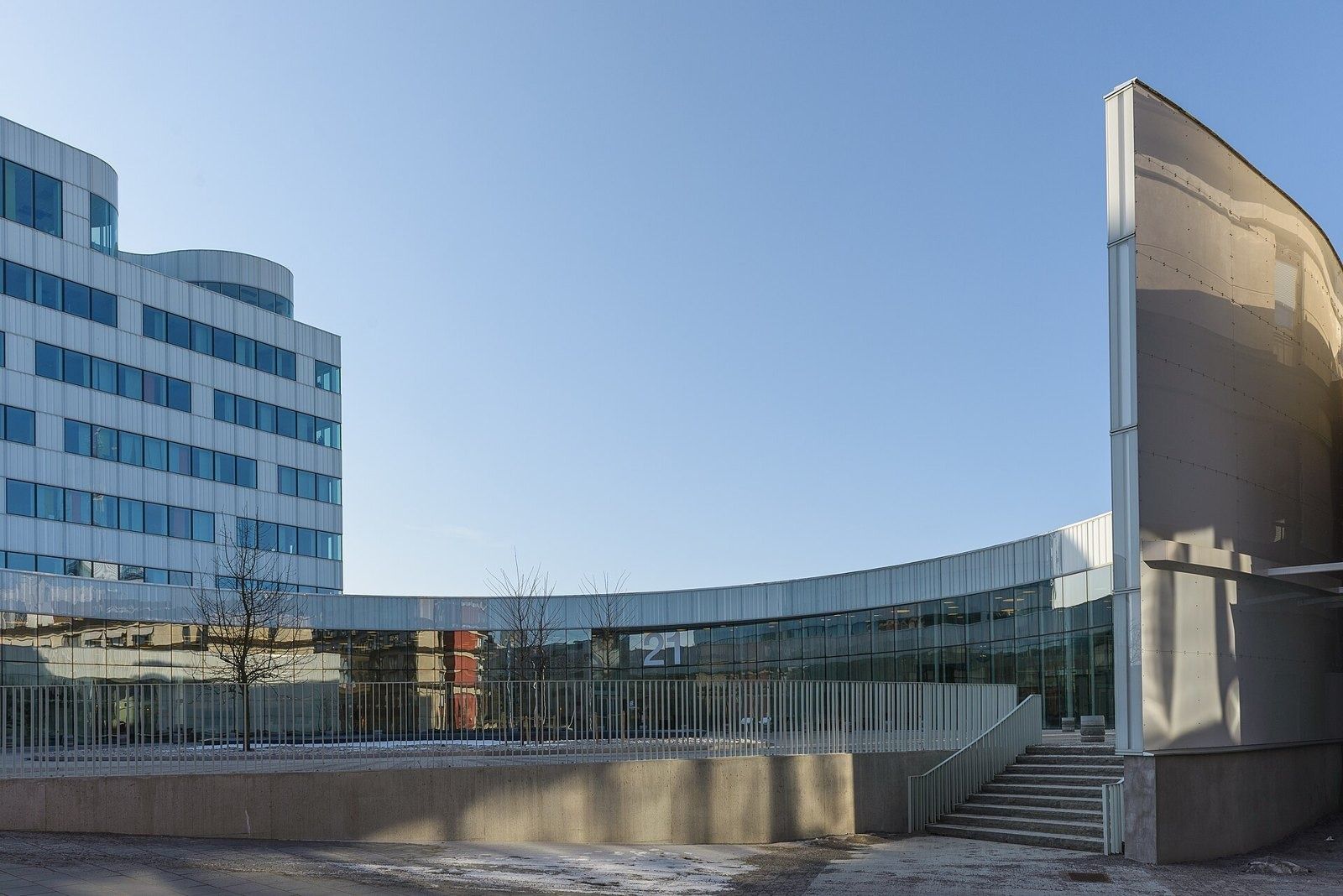 Ericsson: Low curved glass wing and steps beside a white office block