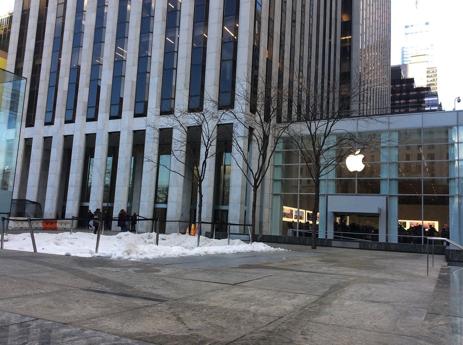 The Estée Lauder Companies: Marble-clad base of a skyscraper with a paved plaza and bare trees in winter