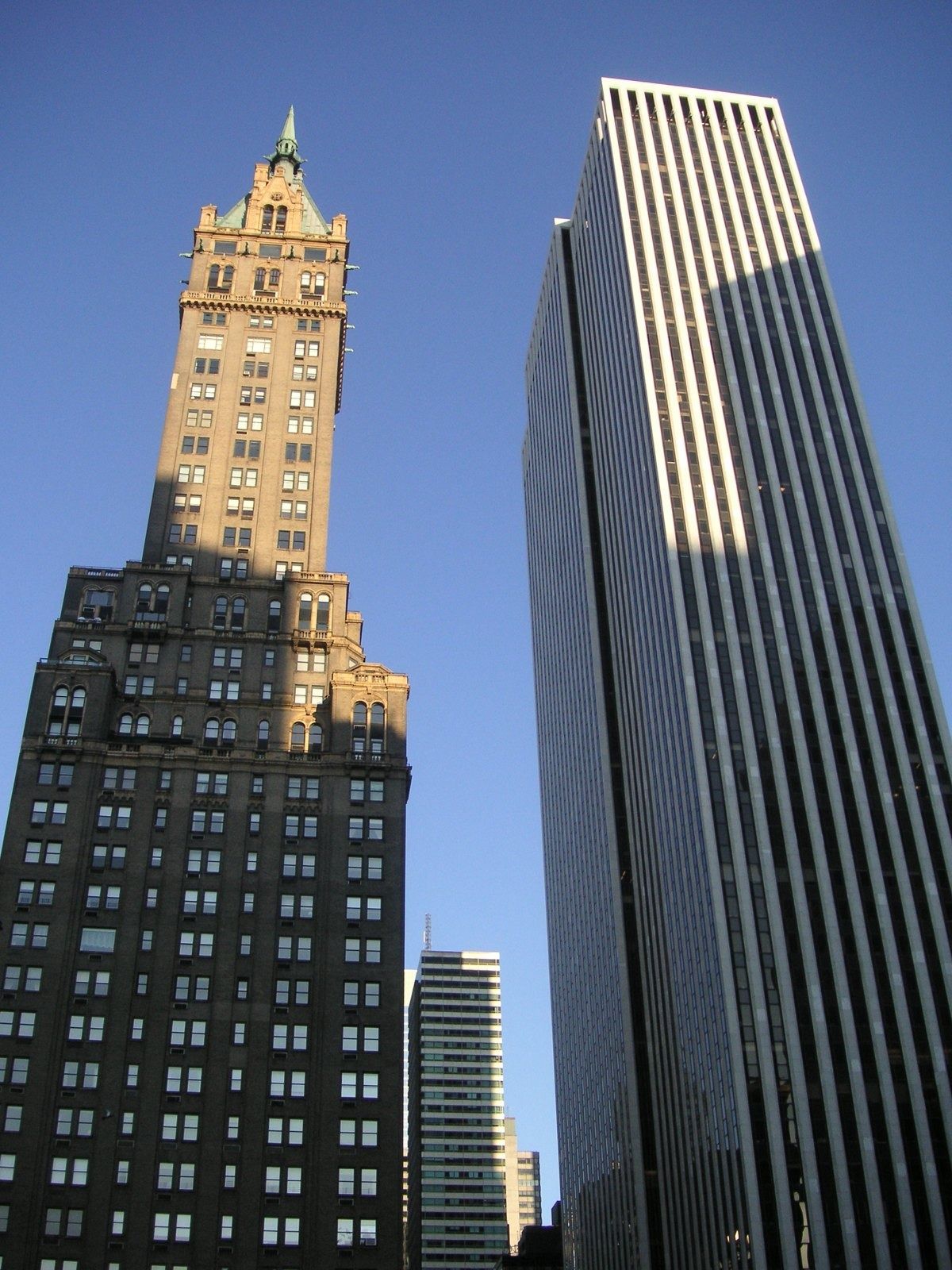 The Estée Lauder Companies: Ornate brown tower and a striped skyscraper side by side in afternoon light