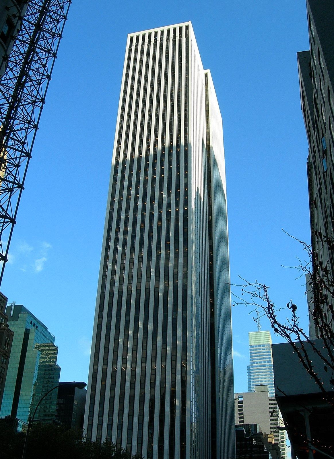 The Estée Lauder Companies: Slender white-striped tower against a blue sky with a crane at the side