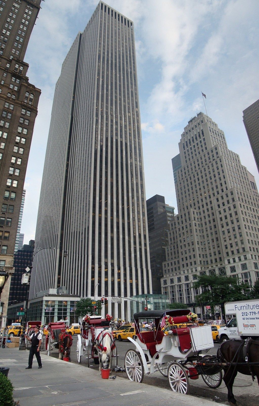 The Estée Lauder Companies: Tall striped tower behind a row of horse carriages parked along the street