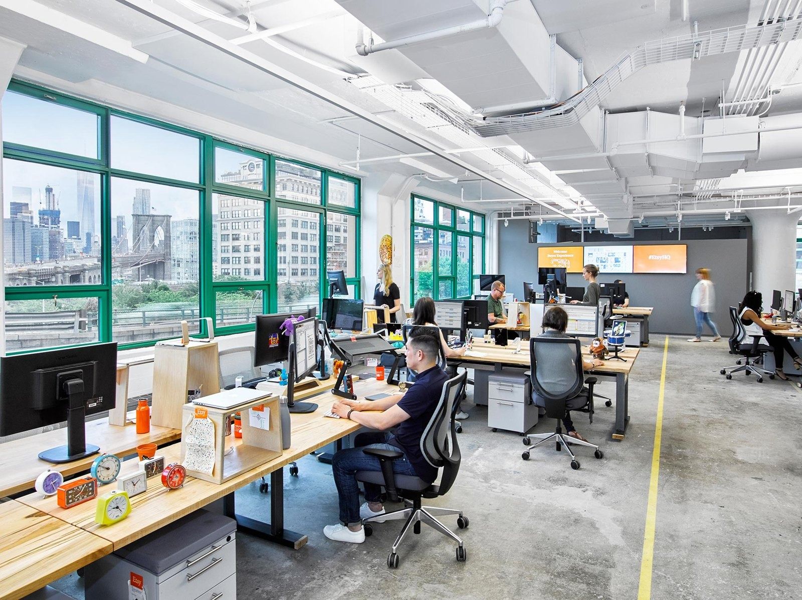 Etsy: Desk area with large green-framed windows looking toward the Manhattan Bridge