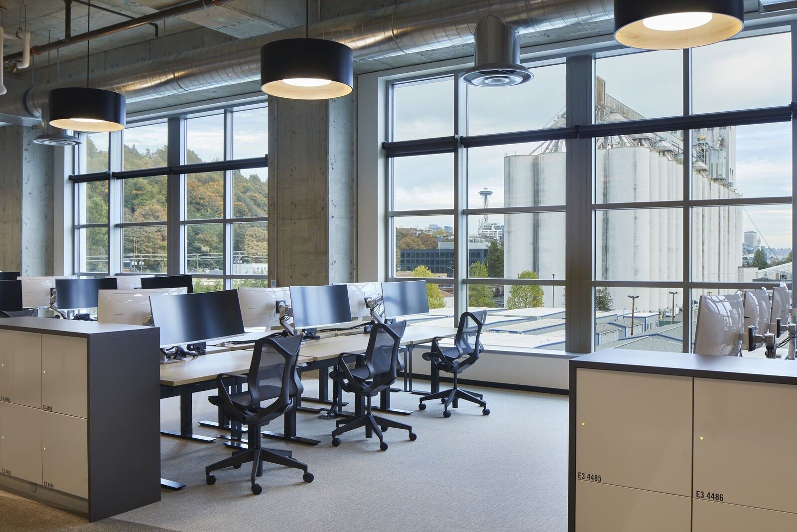Expedia Group: Desks by tall factory-style windows