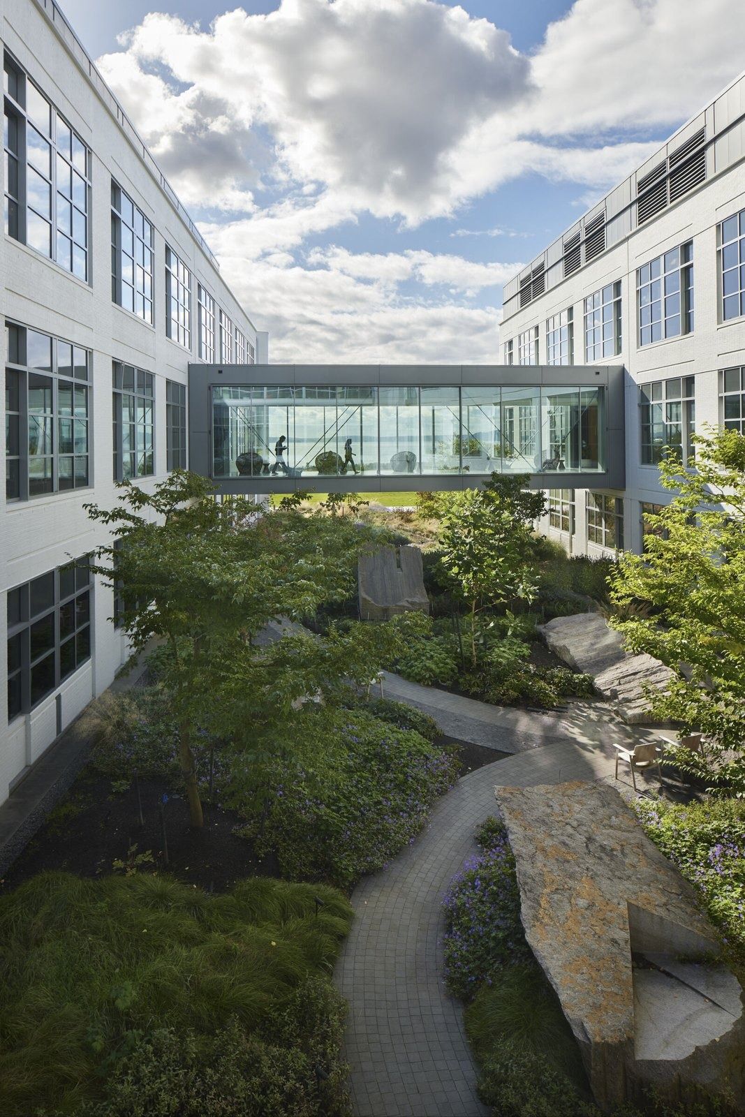 Expedia Group: Garden courtyard between two buildings with a glass bridge