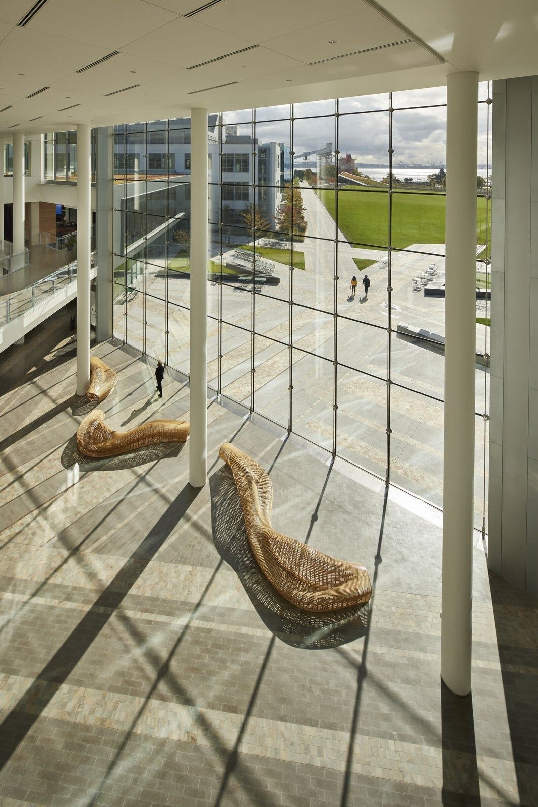 Expedia Group: Glazed corridor with lounge chairs overlooking the lawn