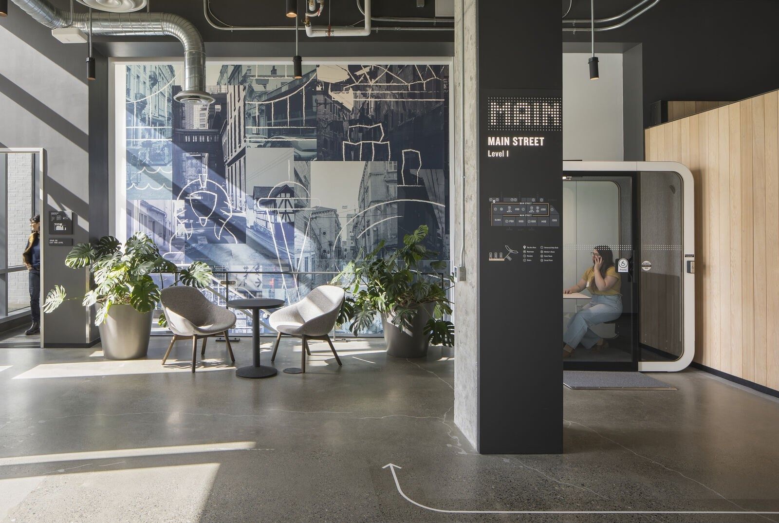 Expedia Group: “Main Street” wayfinding wall with plants and phone booths