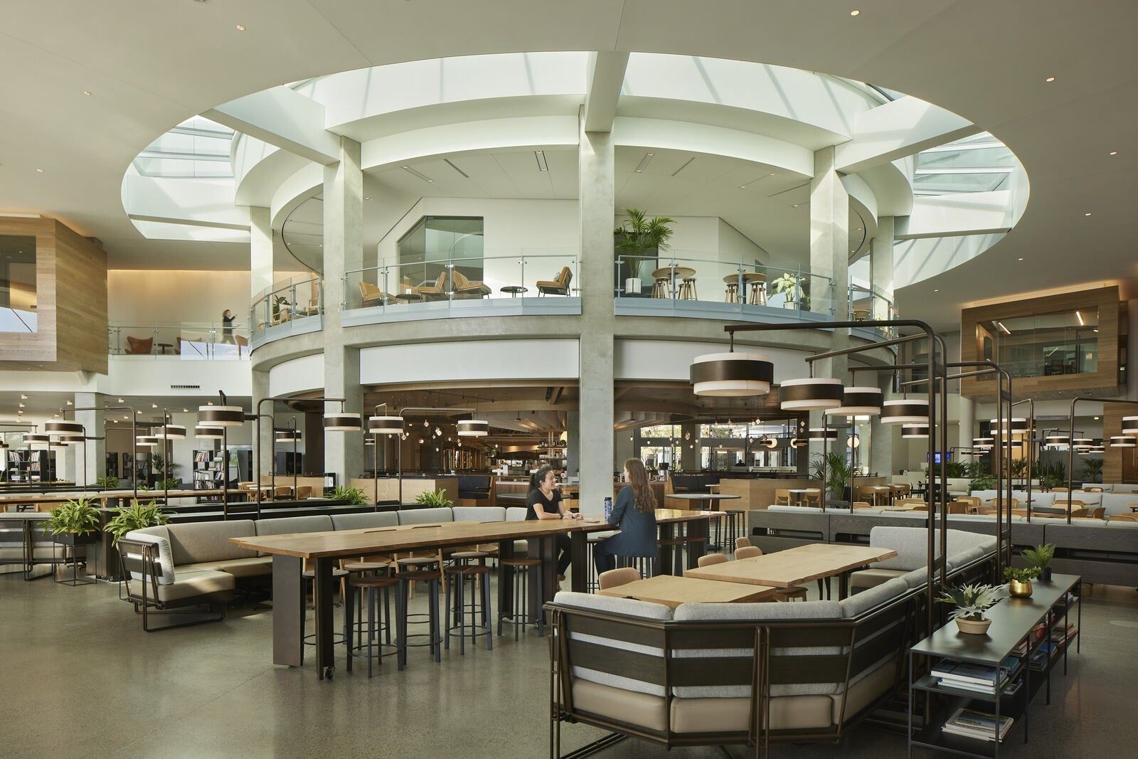 Expedia Group: Market hall with a round skylit atrium, counters and long tables