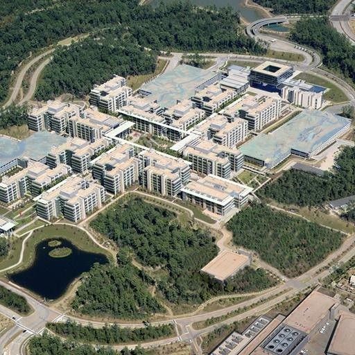 ExxonMobil: Aerial view of office buildings in a forest around a lake