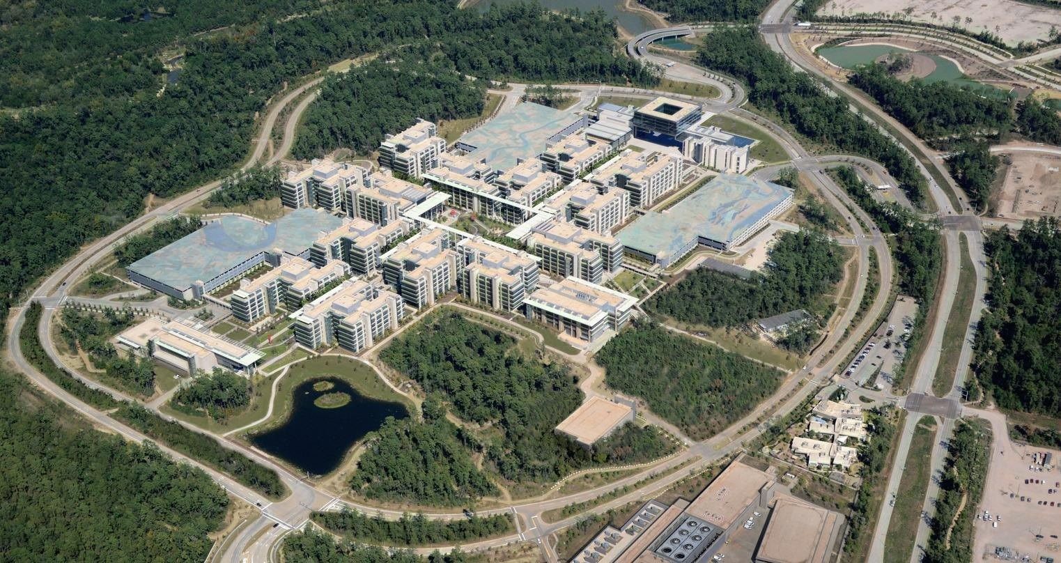 Aerial view of office buildings in a forest ringed by a road