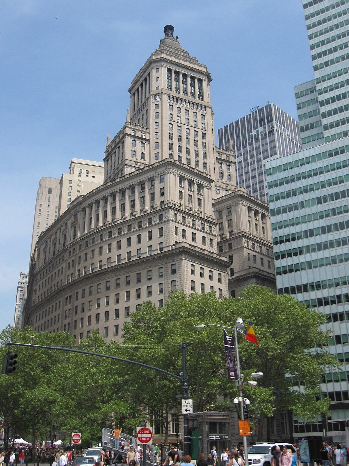 Tall stone office building on a corner with a stepped tower